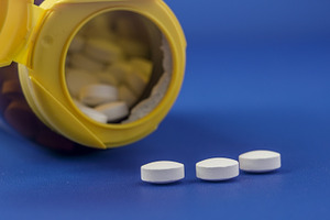 Bottle of white pills spilling onto, a Health & Medical Photo by 1miromiro