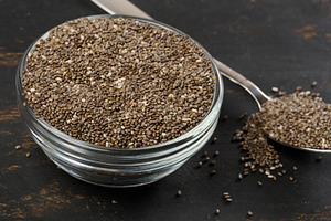 Clear glass bowl filled with dry chia seeds, top view, a Food & Drink Photo by ndanko