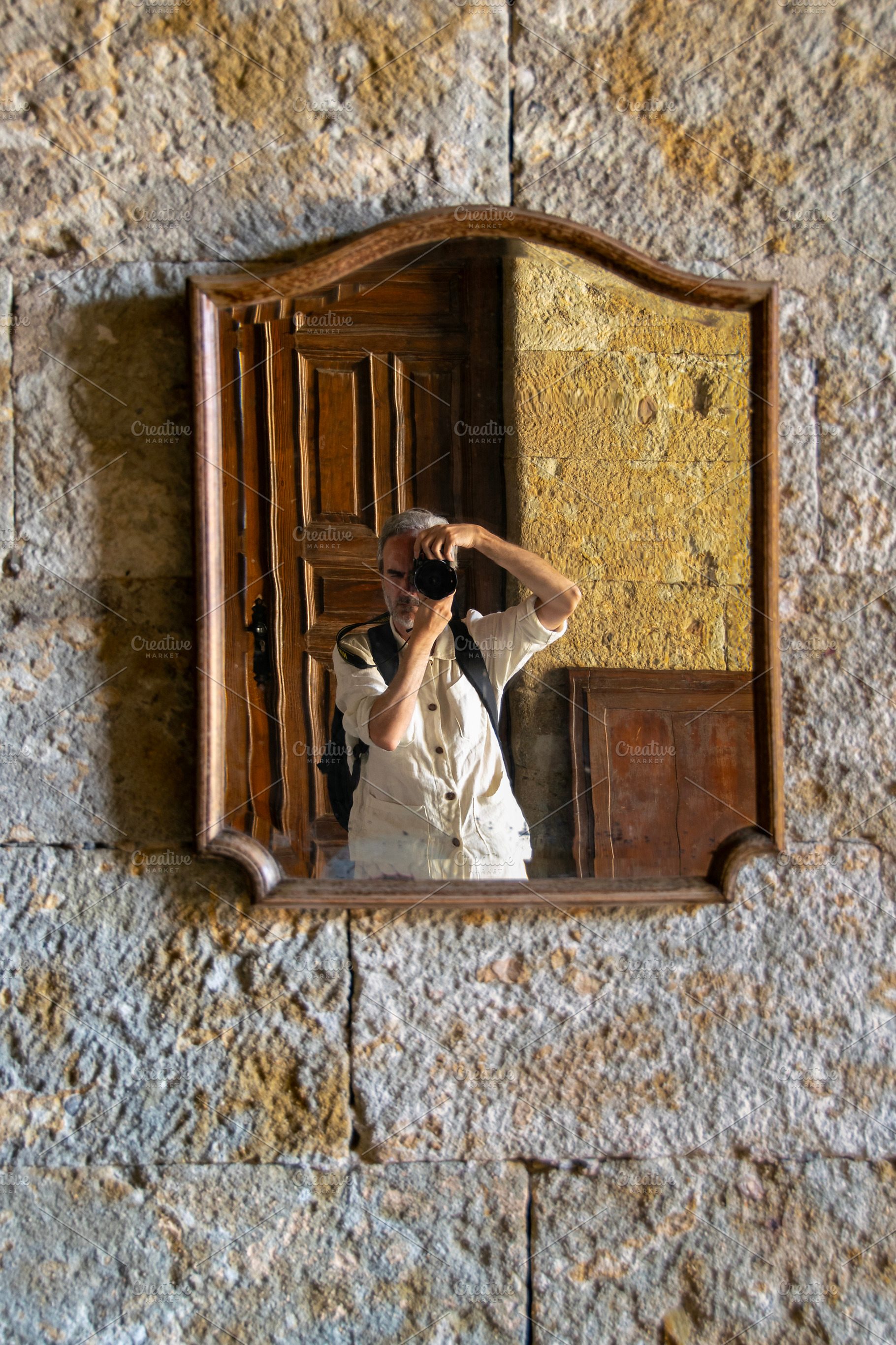 Man photographing a rustic stone wall mirror, an Animal Photo by DanFLCreativo