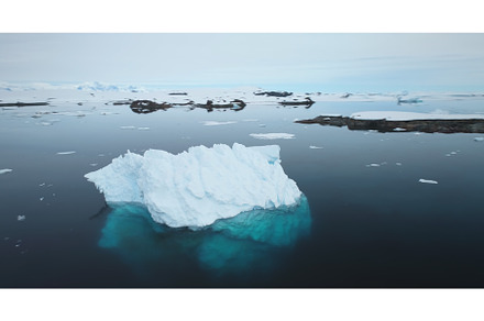 Iceberg drifts cold ocean bay near