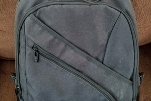Backpack with sunglasses resting on couch, a Holiday Photo by DanFLCreativo