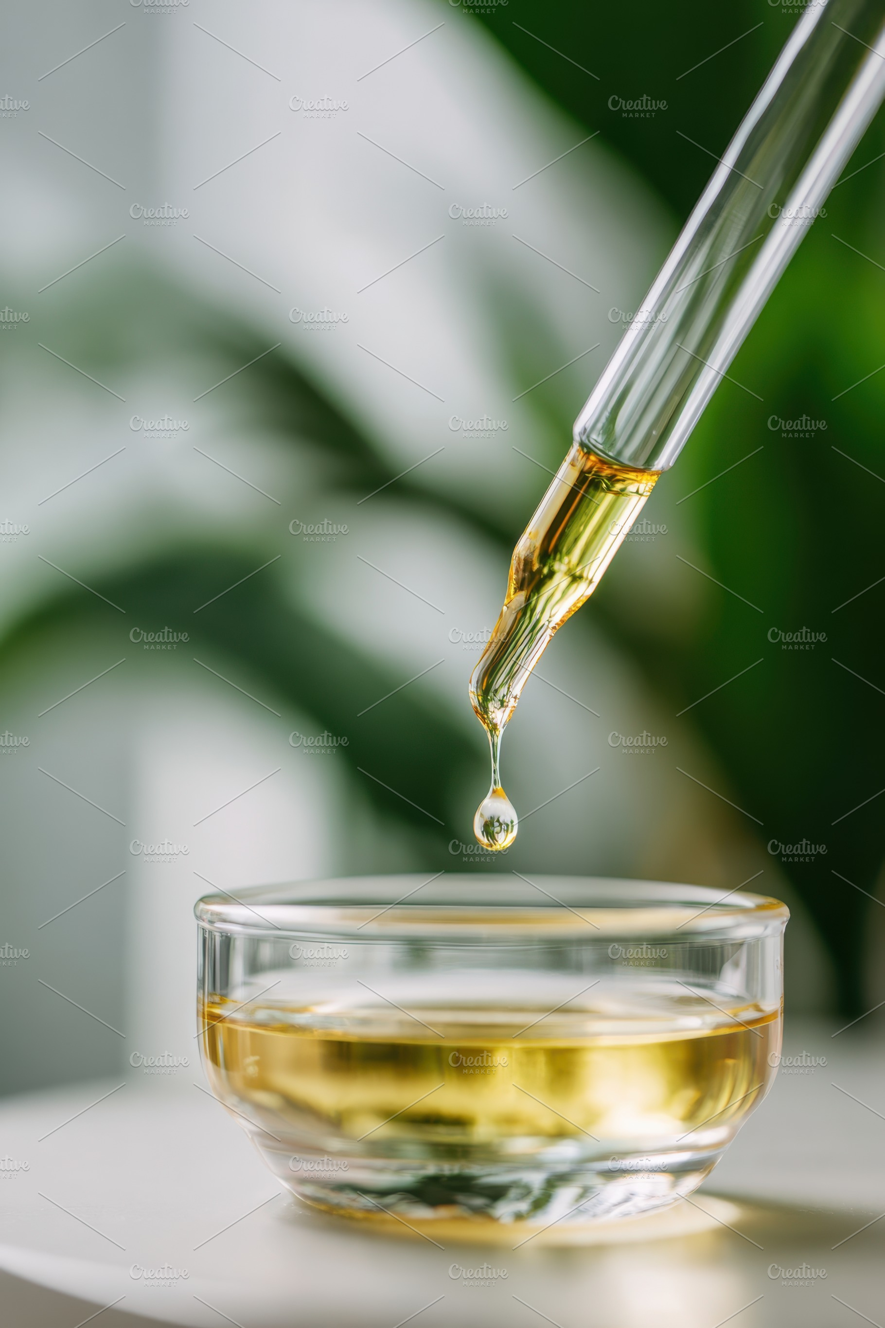 Close-up of dropper releasing amber liquid, a Health & Medical Photo by AlyaAnd