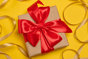 A gift box wrapped in craft paper and tied with a large bright r, a Holiday Photo by ndanko