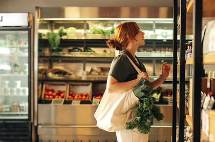 Young woman buying groceries in a supermarket, a Person Photo by Jacob Lund