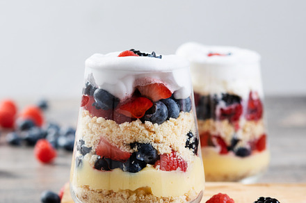 Trifle dessert with berries and cream on wooden table, a Food & Drink Photo by etorres69