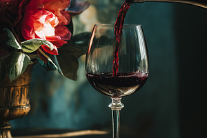 Red wine pouring into a crystal glass, creating a romantic still life with flow, a Food & Drink Photo by Studio ANNA