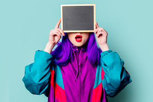 Stylish white girl with purple hair and 80s tracksuit hold board