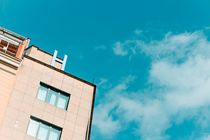 building topped with a blue H letter, a Photo by Nito