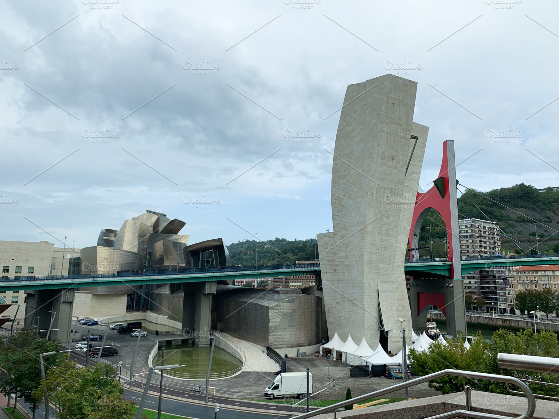 Guggenheim Museum Bilbao with nearby bridge and city view under, a Holiday Photo by sebastianaraw