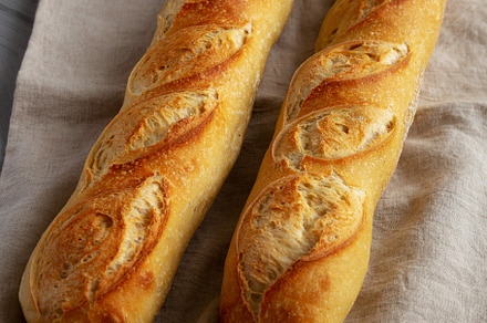 Homemade French Bread Baguette on a gray background, side view., a Food & Drink Photo by LiudmylaChuhunova