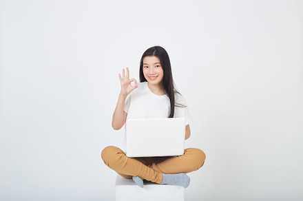 woman sitting using laptop sitting on gray background, a Person Photo by 1981 Rustic studio kan