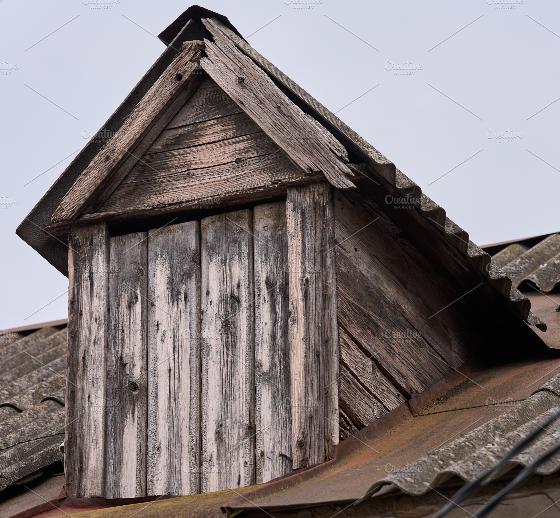Weathered wooden dormer window on an old tiled roof. The aged wo, an Architecture Photo by ndanko
