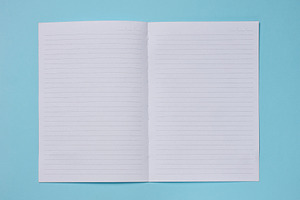 Spread of a clean lined notebook on a turquoise background., a Background Photo by ndanko