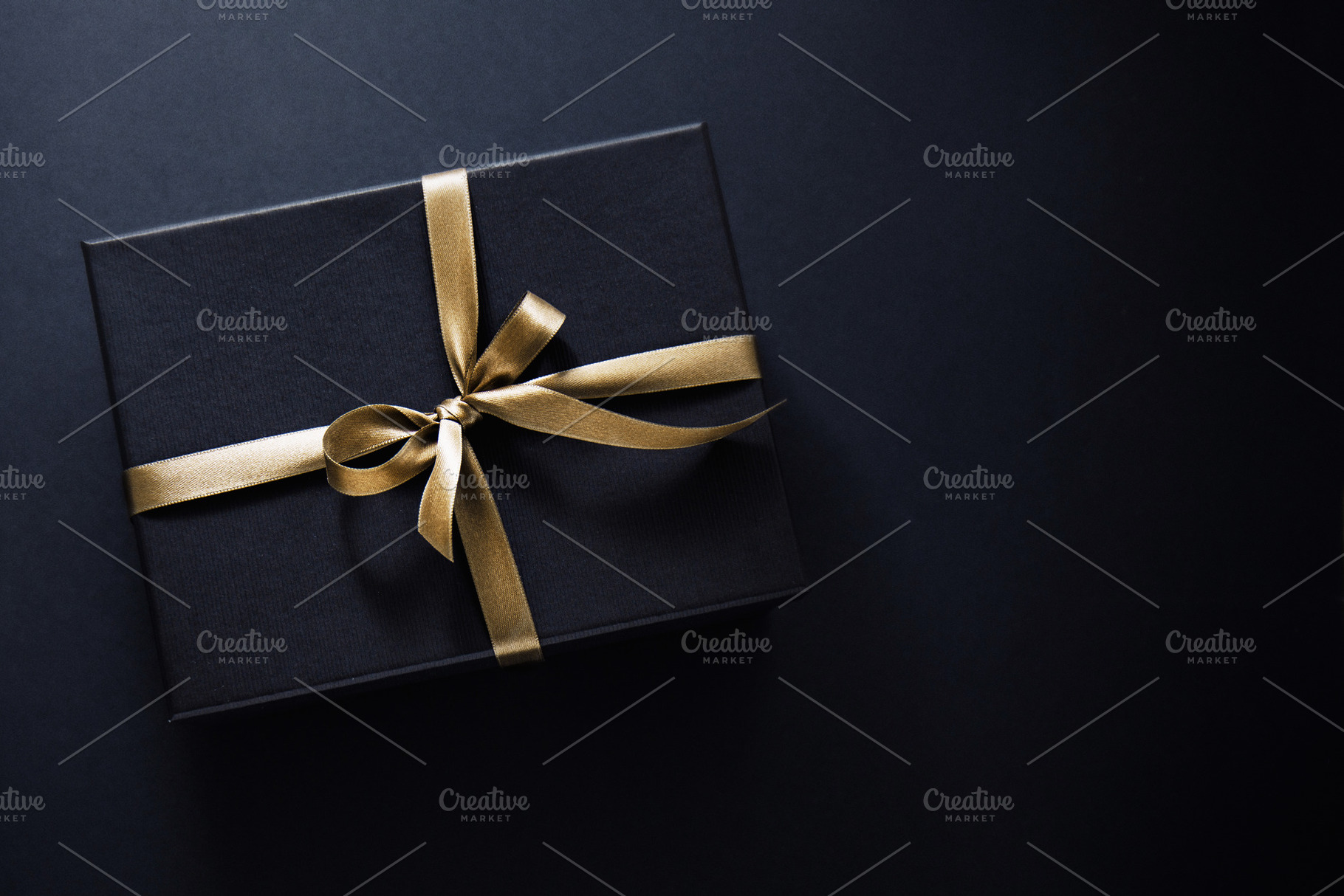 Gift wrapped in dark paper on dark b stock photo containing wrapping and, a Food & Drink Photo by Valeria Art