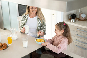 Mother and daughter enjoying healthy breakfast together, a Person Photo by etorres69