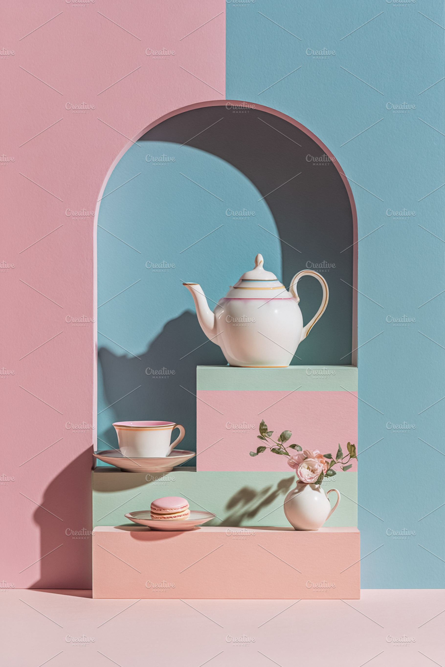 Pastel still life with teapot, teacup, macaron, and flowers arra, a Photo by Studio ANNA