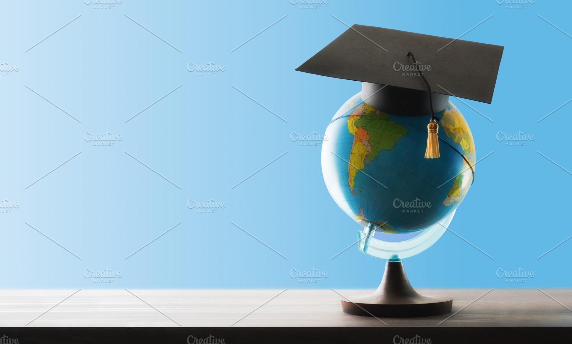 Study abroad concept with globe and mortarboard on wooden table, a School & Education Photo by Davizro's Market