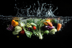 Fresh vegetables splash into water c, a Photo by Tanuart
