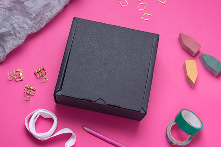 Black Cardboard box on color office desk, a Background Photo by MDBildes
