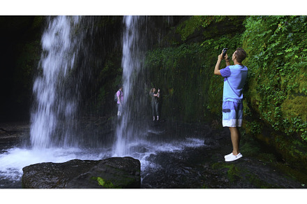 Tourists take pictures of waterfall, a Person Photo by Media Whale Stock