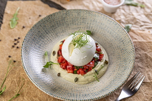 Burrata cheese resting on hummus, a Photo by Grafvision photography