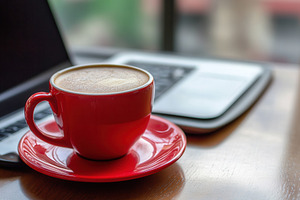 A red coffee cup rests on the table, a Photo by Pavel_design