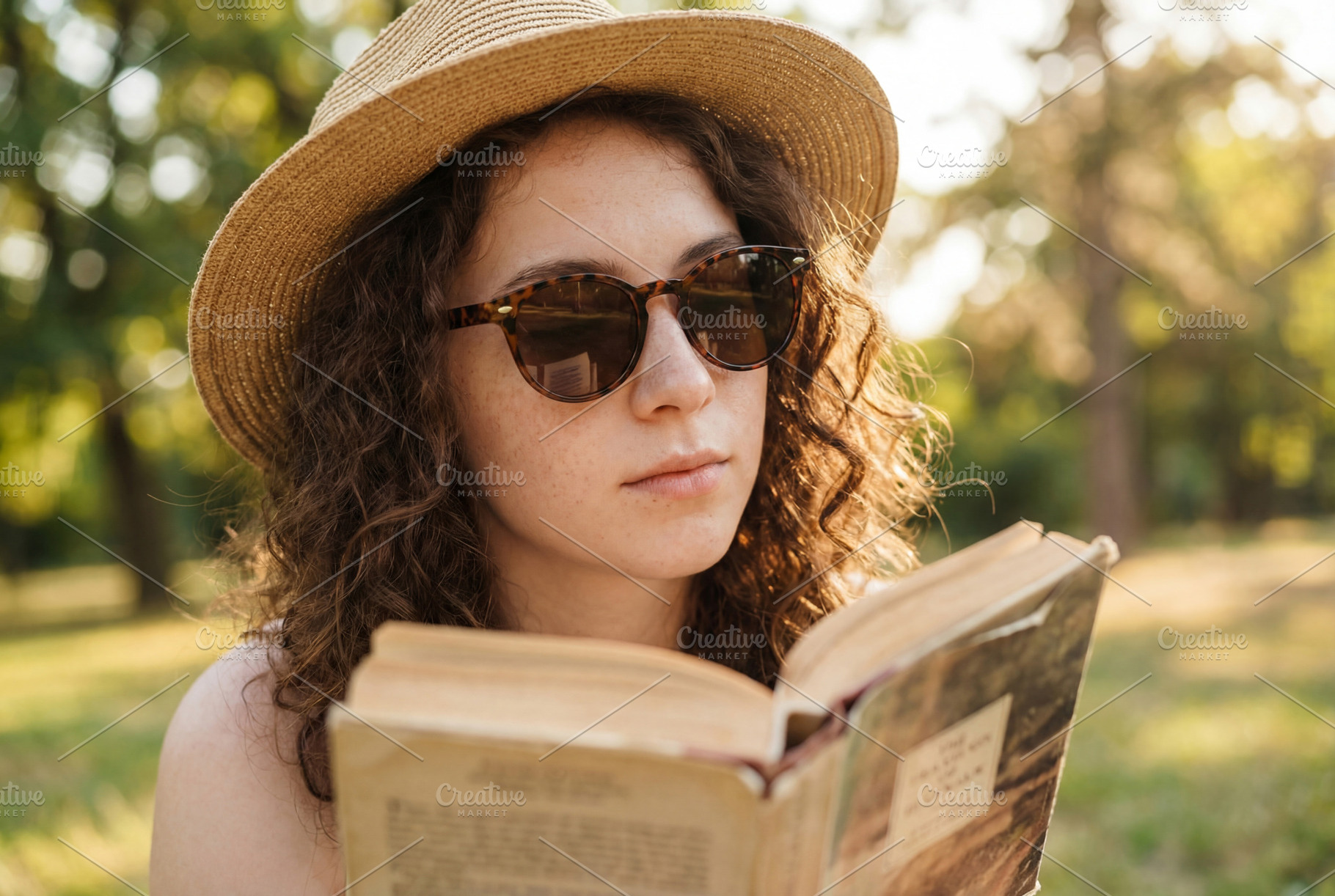 Young Woman Reading Book in a Park, a Person Photo by Virgo Studio