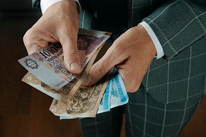 businessman counting hungarian forint banknotes, a Photo by Nito