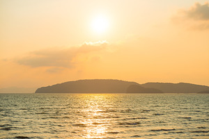 Sunset over calm sea and hills, a Nature Photo by Vapi