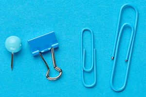 Blue stationery including a pushpin, a binder and two paper clip, a Business Photo by ndanko