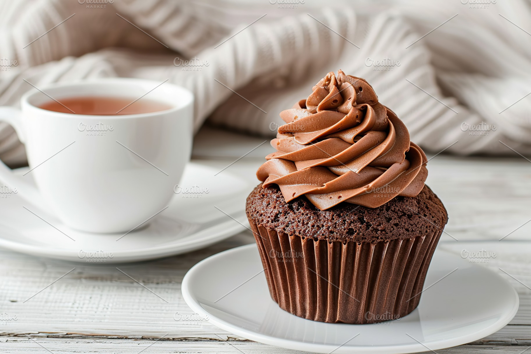 Chocolate cupcake with whipped cream and cup of tea on wooden table, a Food & Drink Photo by AlyaAnd