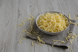 Organic Shredded Mozzarella Cheese in a Bowl, side view. Copy sp, a Food & Drink Photo by LiudmylaChuhunova