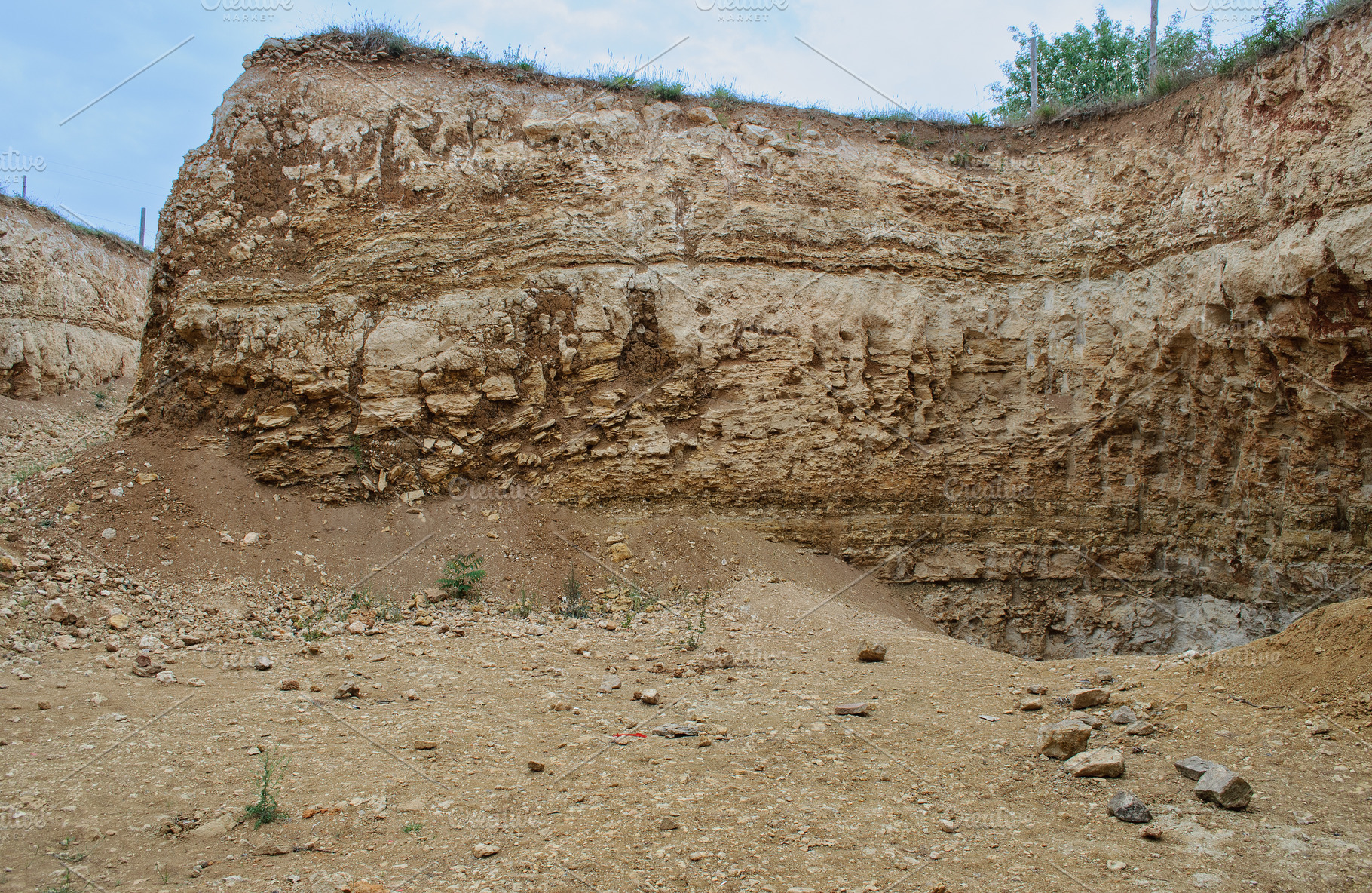 High cliff and quarry with exposure of layered rocks and sand, a Nature Photo by ndanko