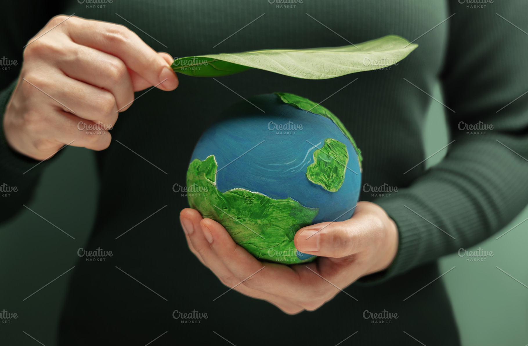 Hands holding globe with green leaf symbolizing environmental pr, a Photo by salmon.black
