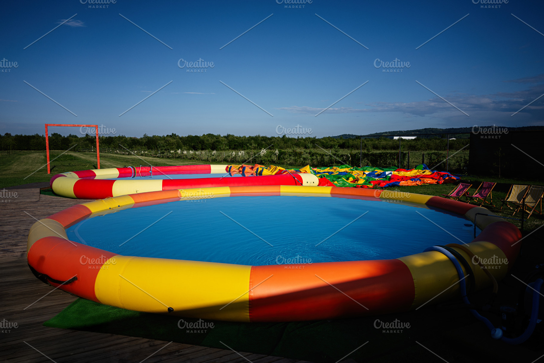 Vibrant inflatable pool setup under clear skies in a spacious outdoor area, a Photo by AS photostudio