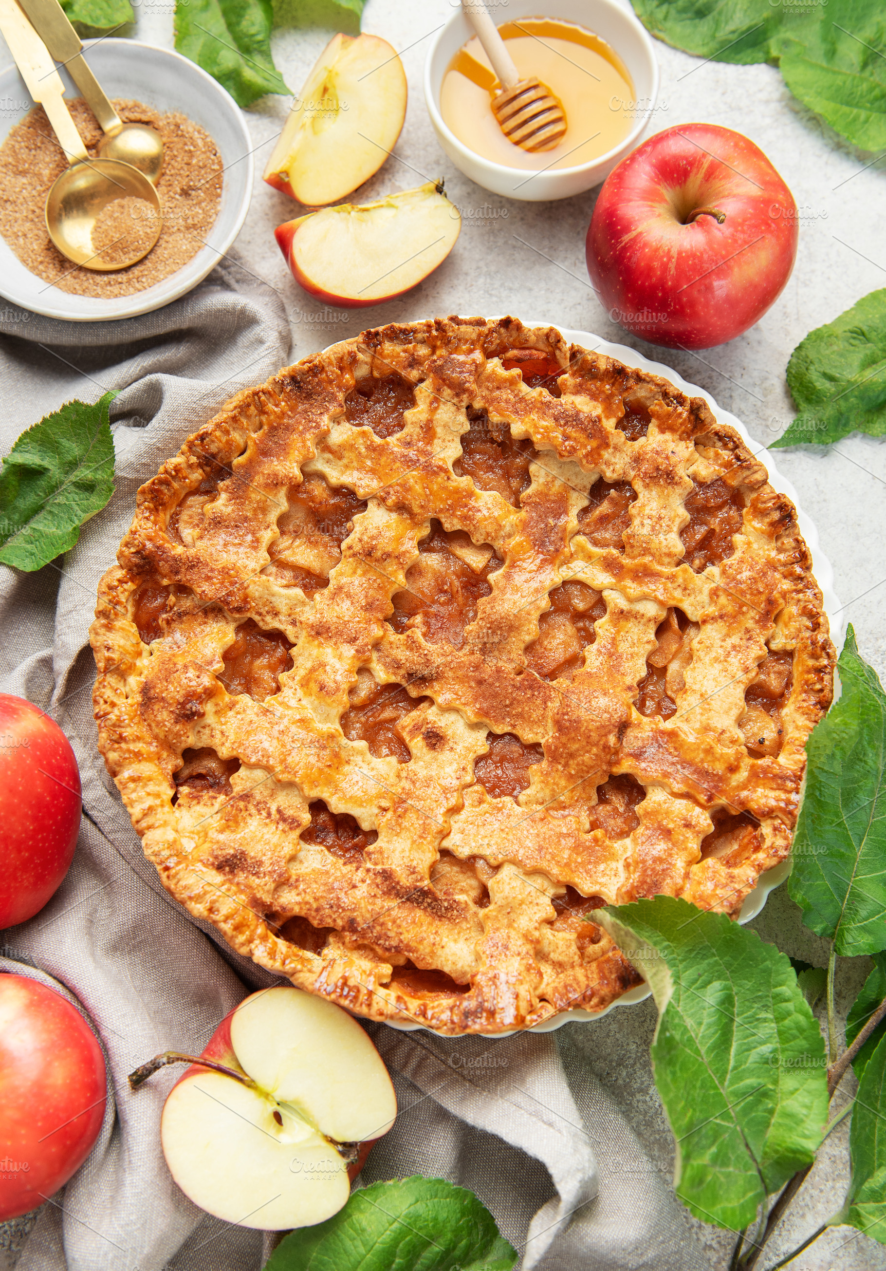 Freshly baked apple pie decorated with apple slices and leaves o, a Food & Drink Photo by Olena Rudo