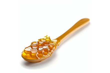 Wooden spoon dripping with golden, a Food & Drink Photo by Ylivdesign