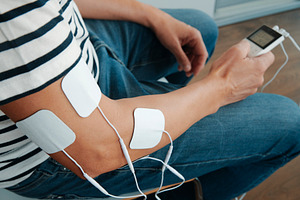 electrode pads attached to the arm of a man, a Photo by Nito