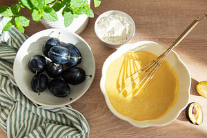 Baking plum cake ingredients with batter and flour, a Food & Drink Photo by Olena Rudo