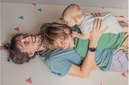 Father, son, and newborn baby lying