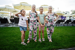 Four young girls posing together on a summer afternoon in a park setting, a Photo by AS photostudio