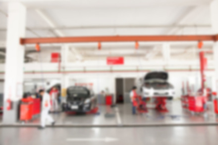 Blurred of inside car garage with cars being under maintenance and technicians for background, an Industrial Photo by Twinster Photo