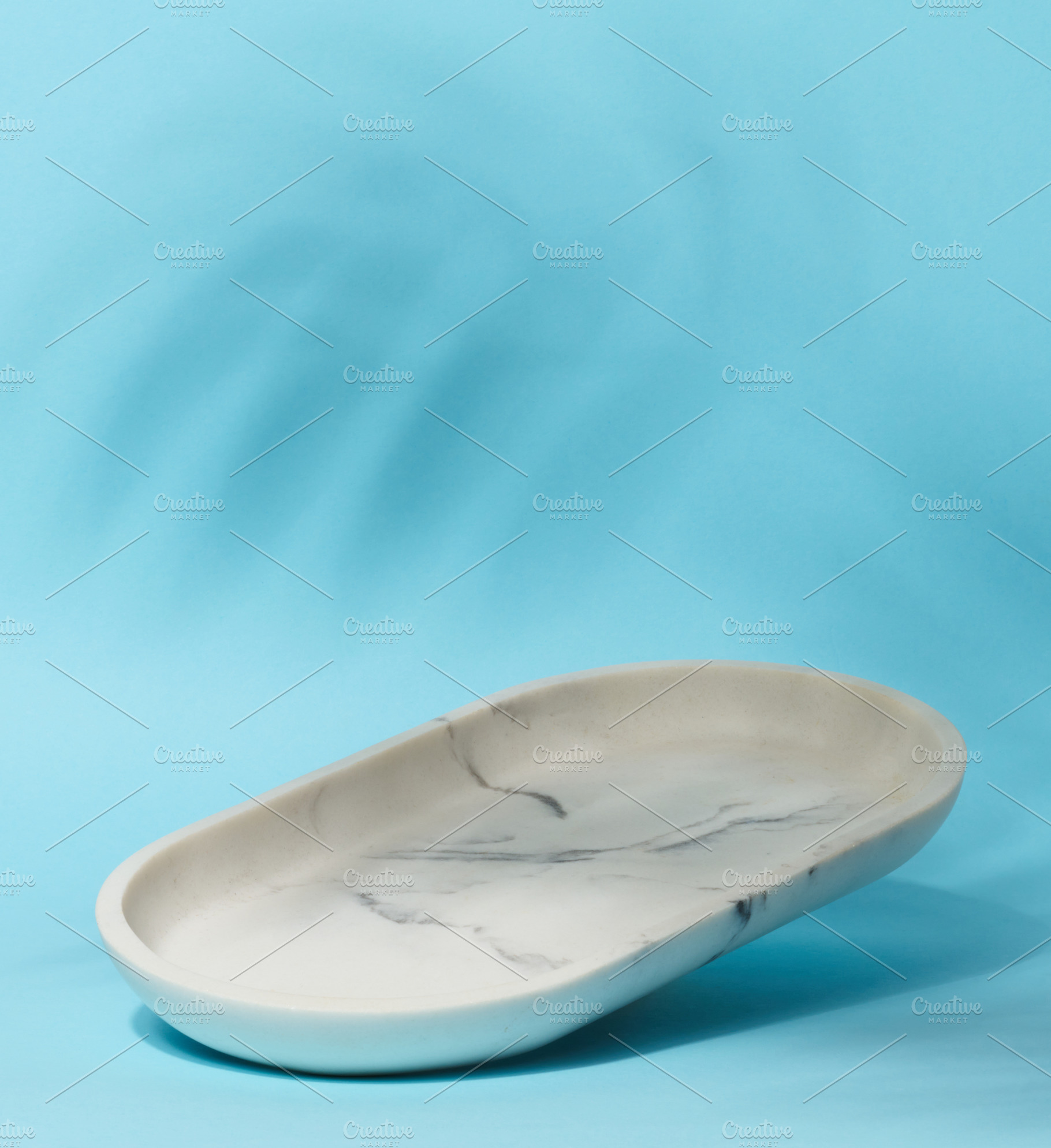 An empty, oval shaped soap dish made of white marble with gray v, a Background Photo by ndanko