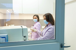 Two female lab technicians working with modern medical equipment, a Health & Medical Photo by Antonio Gravante Market