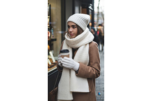 Young woman in winter attire holding, an Illustration by tilialucida