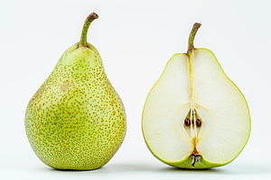 Green pear and pear half isolated on white background, a Food & Drink Photo by AlyaAnd