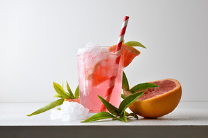 Refreshing grapefruit drink with ice on a white isolated backgro, a Food & Drink Photo by Davizro's Market