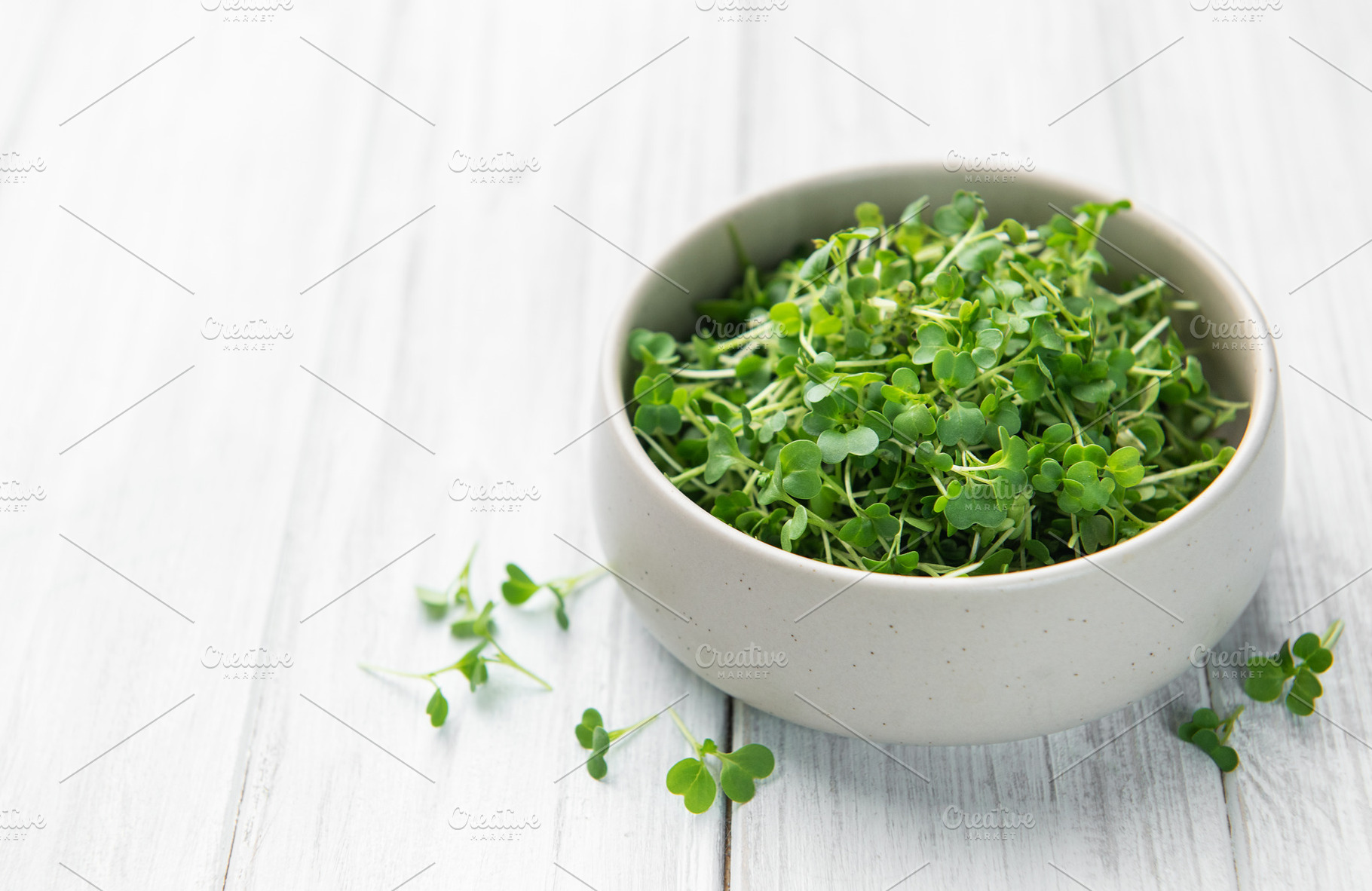 Fresh microgreens in bowl on white wooden table, a Food & Drink Photo by Olena Rudo