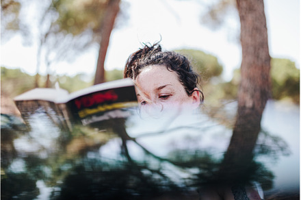 Young woman reading a book in a park, a Holiday Photo by Manu Reyes