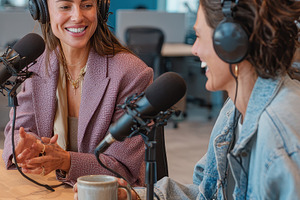 Two women podcasting in a modern off, a Photo by Pixeness Studio